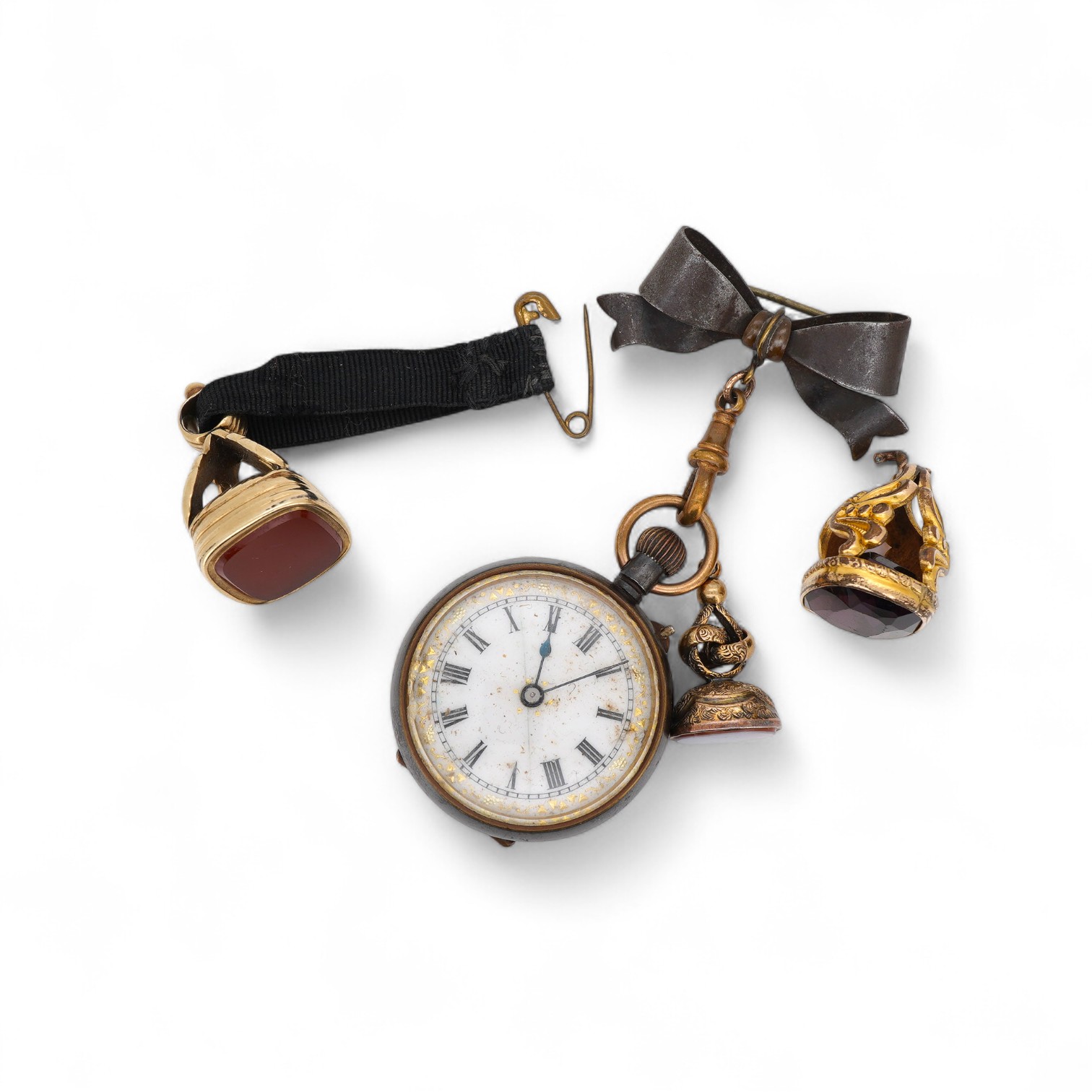 Three assorted yellow metal overlaid and gem set fob seals, including carnelian, largest 26mm, together with a gun metal fob watch, with yellow metal inset plaque.